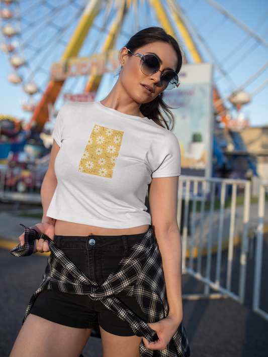 Woman wearing a white t-shirt with a yellow design and black shorts at an amusement park.